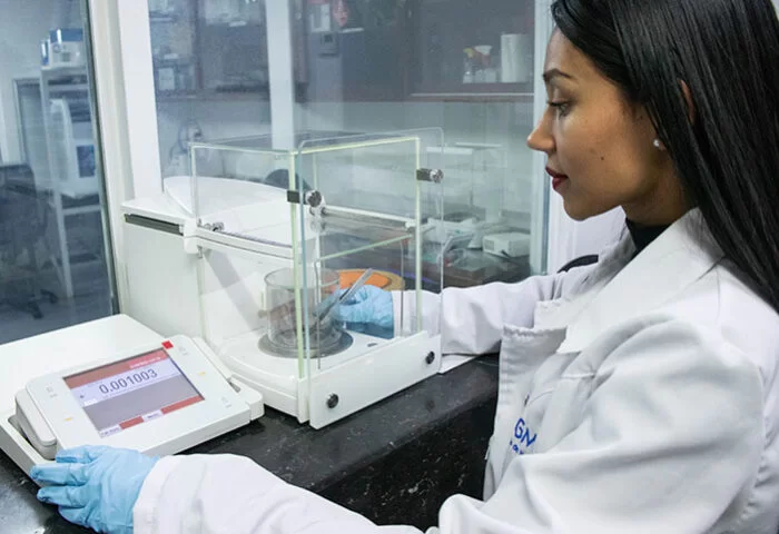 Mujer utilizando balanza para calibrar equipos de medición
